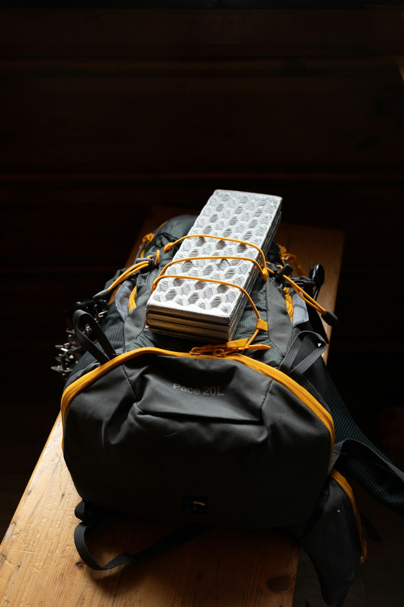 A packed backpack with a sleeping mat secured on top
